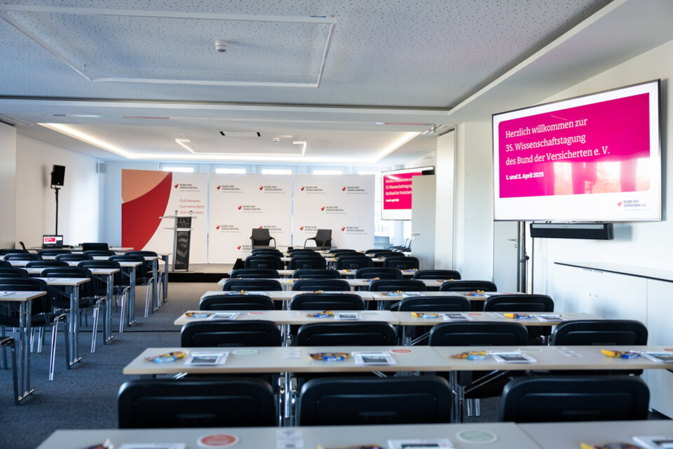 Das Bild zeigt einen Konferenzraum mit Stühlen, Tischen und einer Bühne. | © Valeska Achenbach