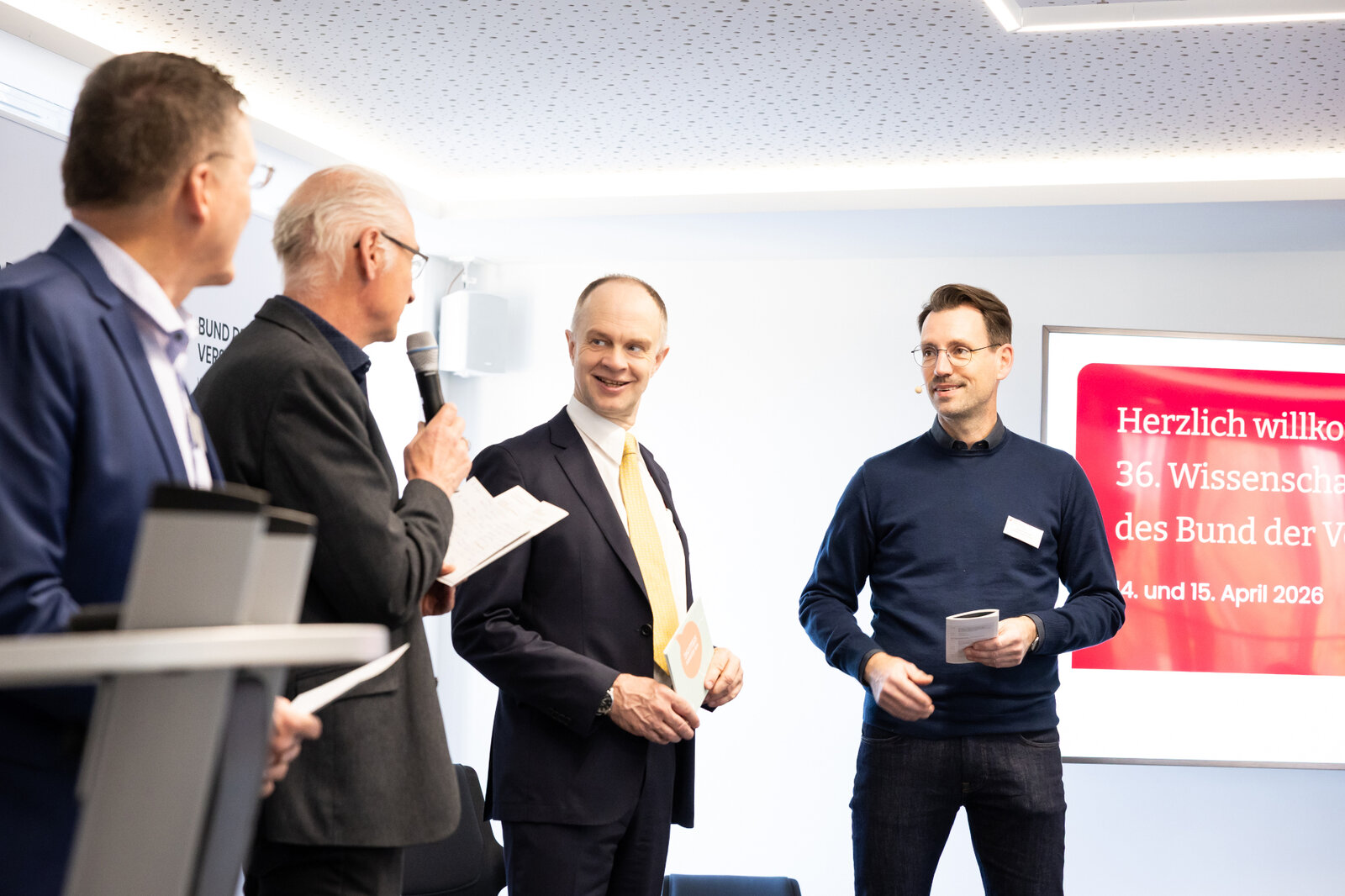  Das Bild zeigt den Wissenschaftlichen Beirat des BdV im Gespräch mit BdV-Vorstand Stephen Rehmke auf der Tagungsbühne. | © Valeska Achenbach