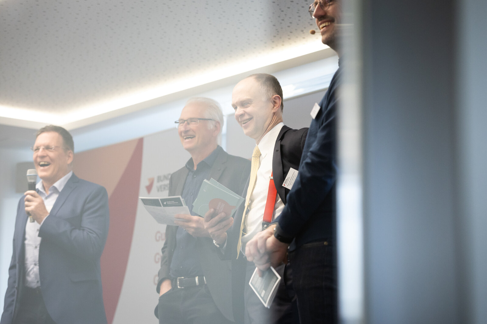  Das Bild zeigt den Wissenschaftlichen Beirat des BdV im Gespräch mit BdV-Vorstand Stephen Rehmke auf der Tagungsbühne. | © Valeska Achenbach