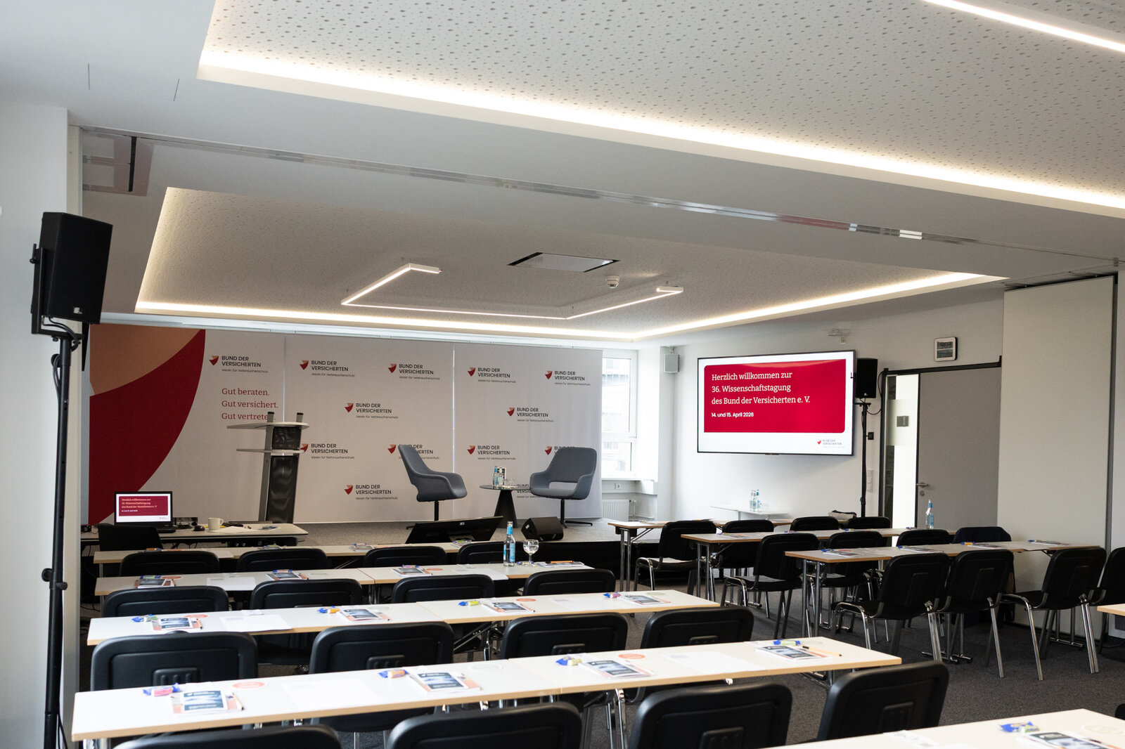 Das Bild zeigt einen Konferenzraum mit Stühlen, Tischen und einer Bühne. | © Valeska Achenbach