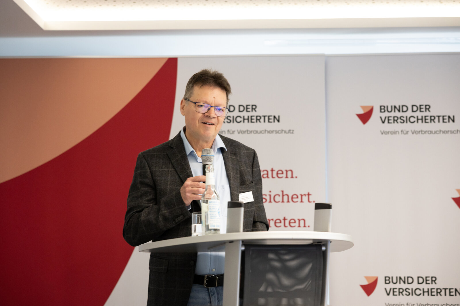 Das Bild zeigt BdV-Aufsichtsrat Rüdiger Falken an einem Redner-Pult vor Publikum. | © Valeska Achenbach