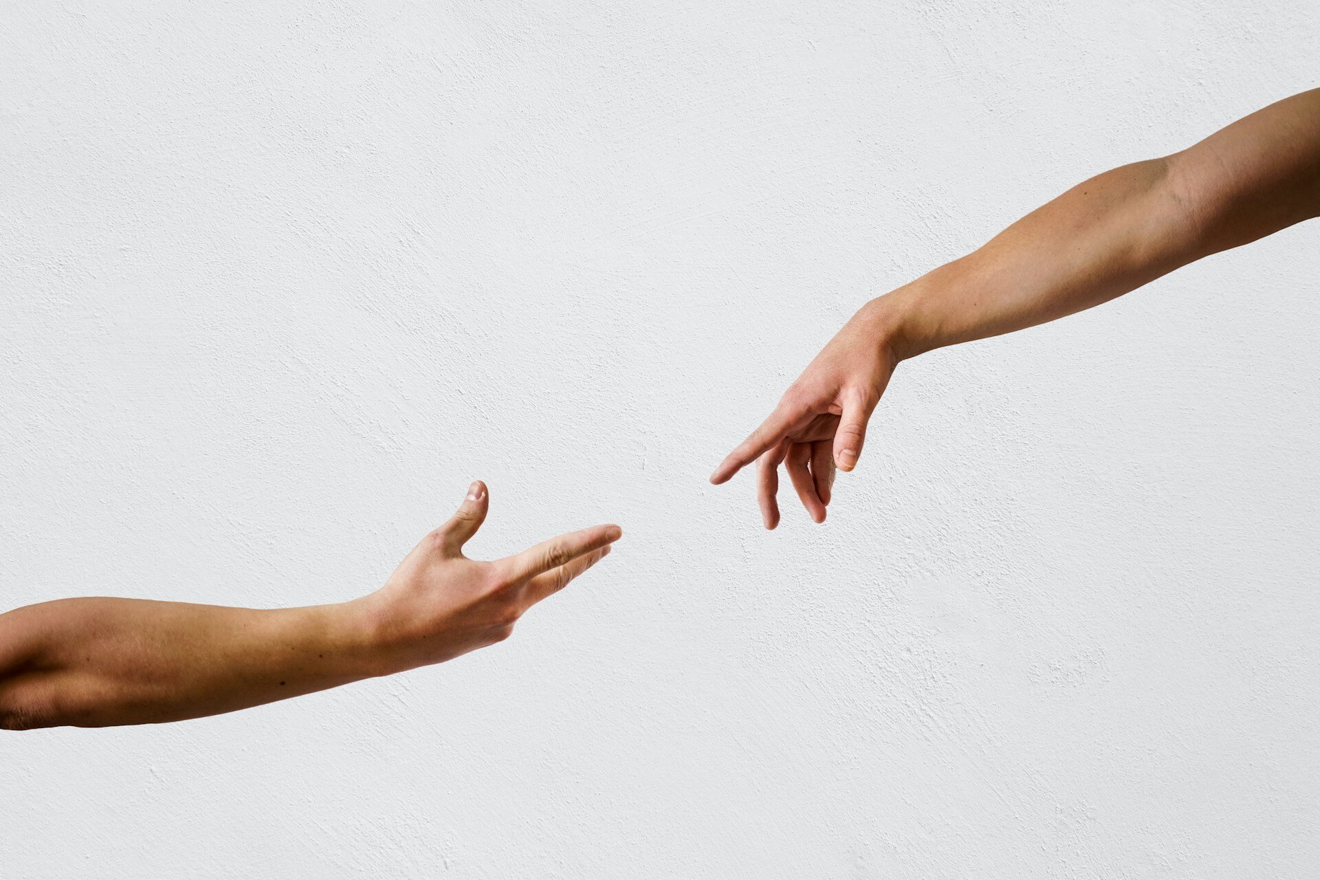 Navigating Cancer Insurance: Key Details You Must Know | © Sebastian Dumitru / Unsplash Auf dem Bild sieht man zwei Hände, die sich annähern, aber noch nicht berühren | © Sebastian Dumitru / Unsplash