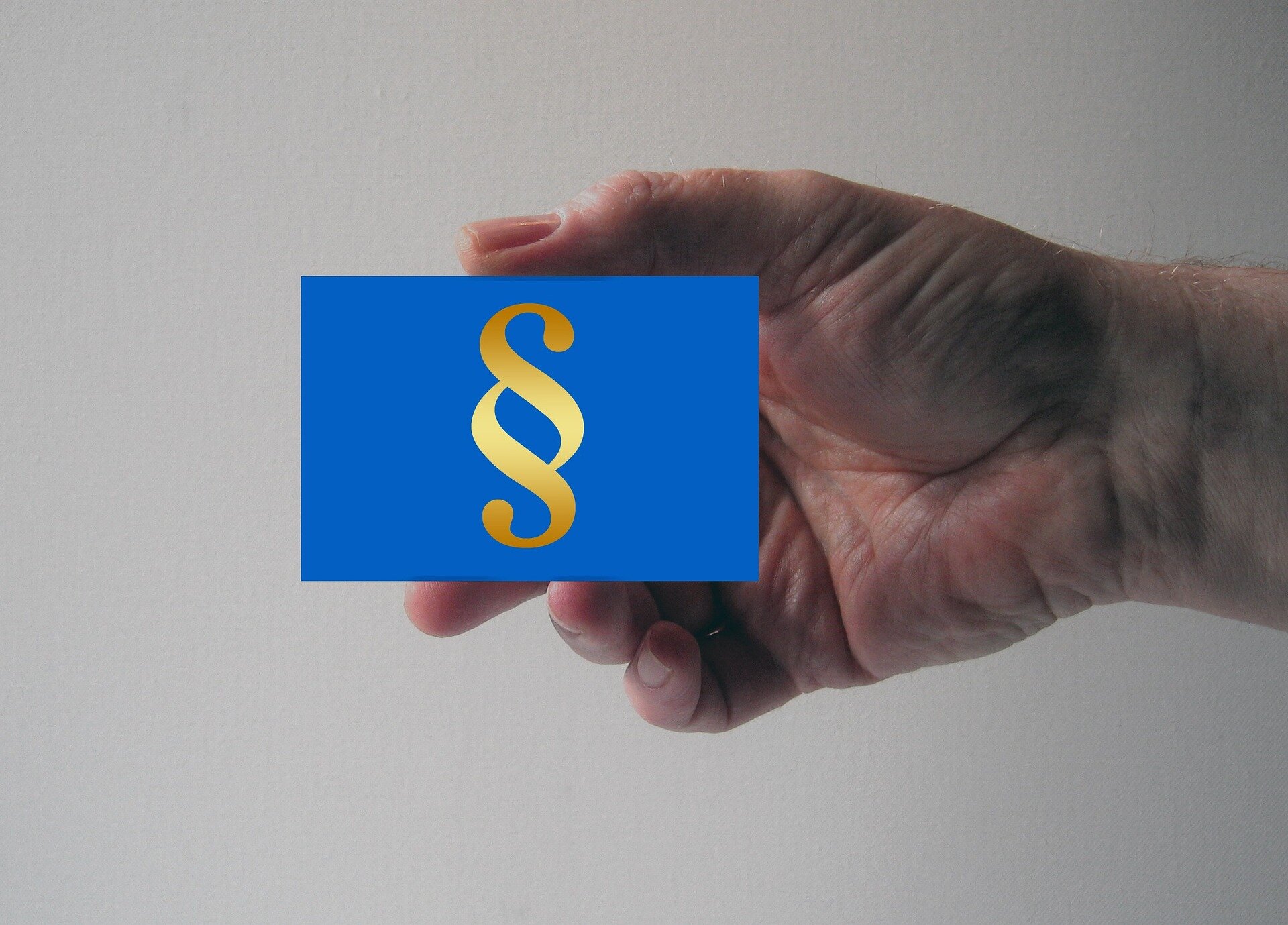 Quality of Insurance Advice: Navigating Complex Products | © geralt / Pixabay Auf dem Bild sieht man eine Hand, die eine blaues Bild mit einem Paragraphen-Zeichen in die Kamera hält | © geralt / Pixabay