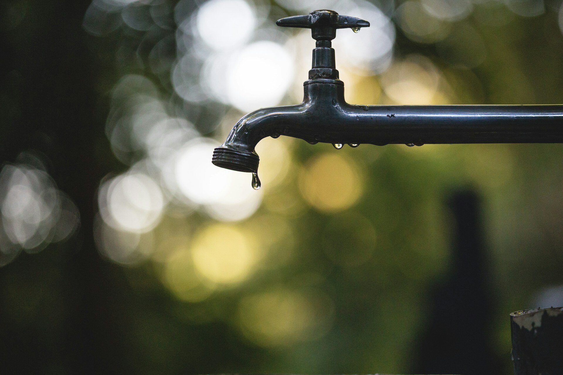 Welche Versicherung zahlt bei Leitungswasserschäden | © Luis Tosta / Unsplash Ein tropfender Wasserhahn mit Wassertropfen. | © Luis Tosta / Unsplash