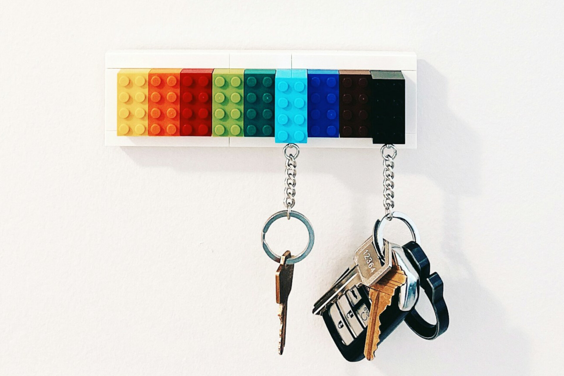 Büroschlüssel verloren? So schützt Sie die Haftpflicht! | © Scott Webb / Unsplash Wandhalterung aus bunten LEGO-Steinen, an der verschiedene Schlüssel hängen, vor weißer Wand. | © Scott Webb / Unsplash