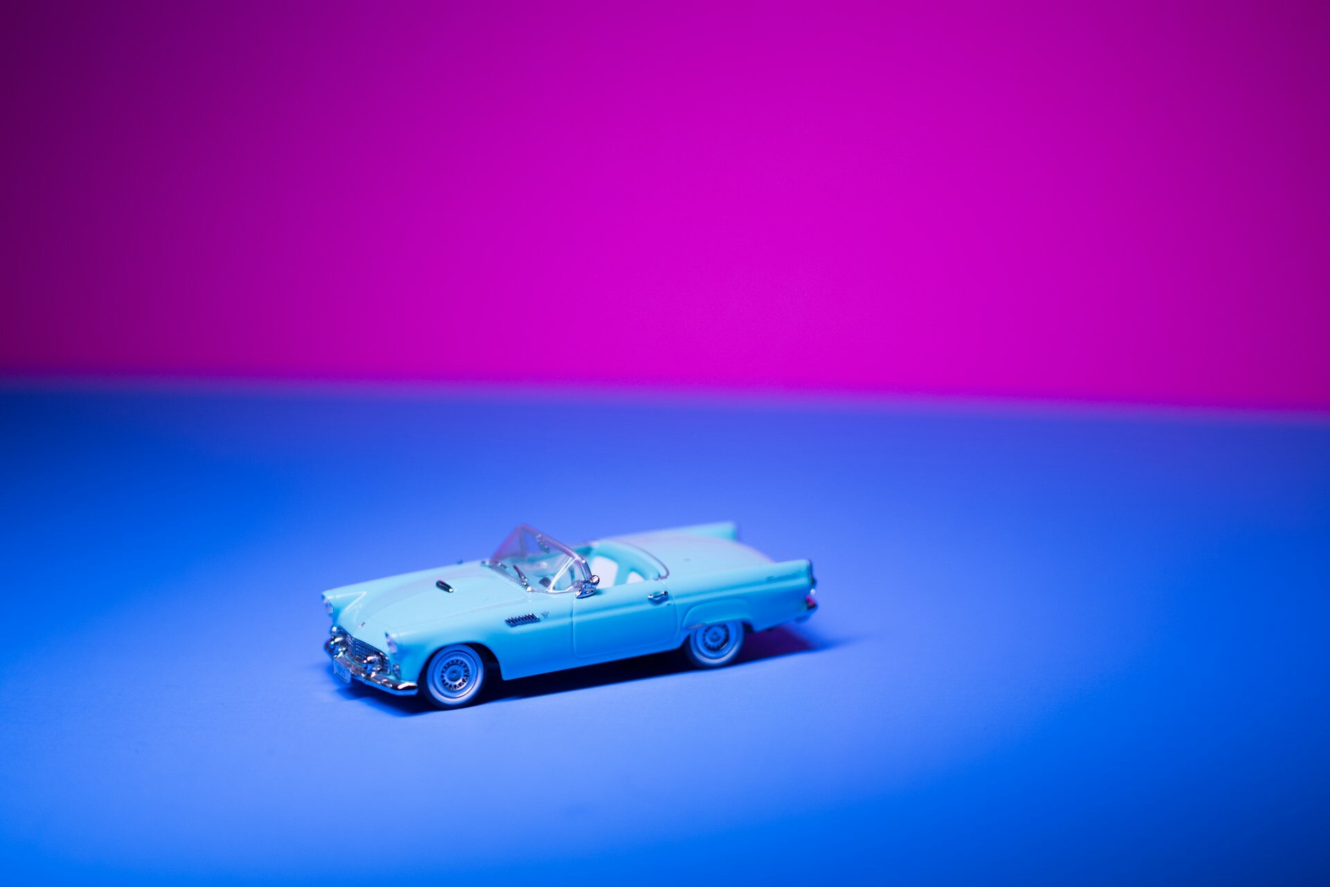 Tipps für den erfolgreichen Wechsel der Kfz-Versicherung | © Ruvim Noga/Unsplash Auf dem Bild sieht man ein Cabrio-Spielzeugauto im Vintage-Optik. es ist klein, hellblau und steht vor einem blauen Boden, der obere Teil des Bildes ist lila. | © Ruvim Noga/Unsplash