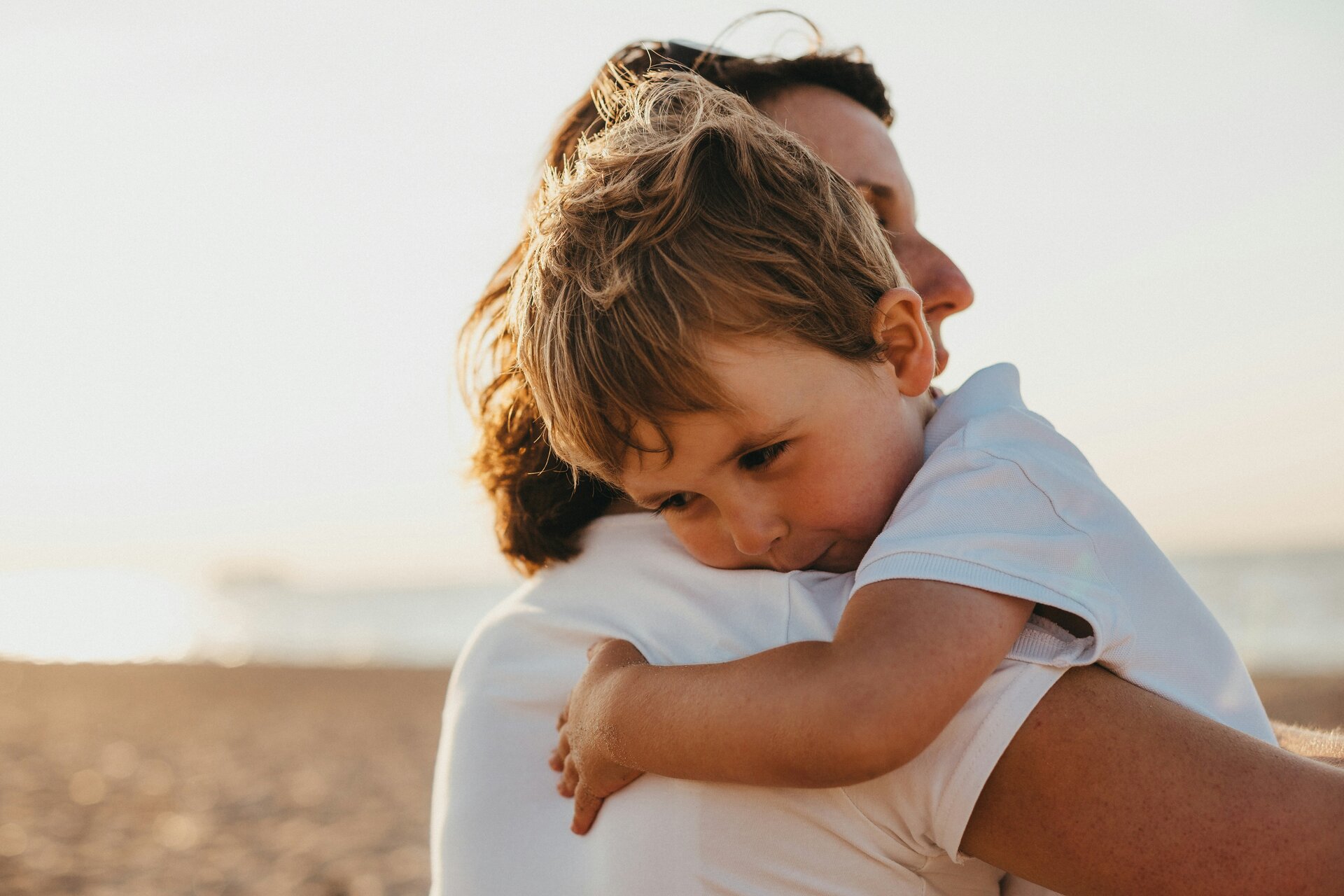 alleinerziehend-welche-krankenversicherung | © Xavier Mouton / Unsplash Das Bild zeigt ein Kind auf dem Arm eines Erwachsenen | © Xavier Mouton / Unsplash