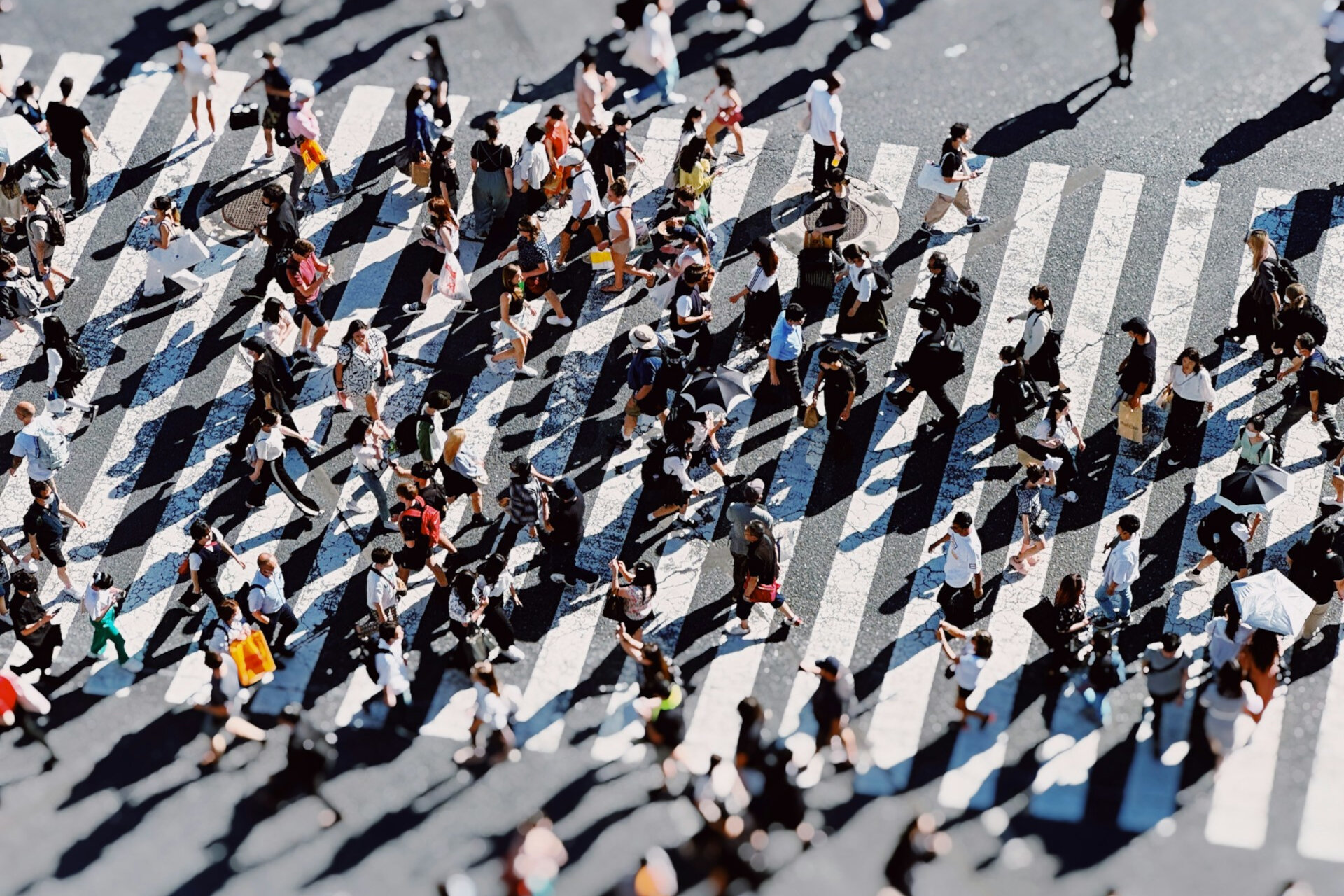  Luftaufnahme einer großen Gruppe von Menschen, die eine Straße überqueren. | © Fahrul Azmi / Unsplash