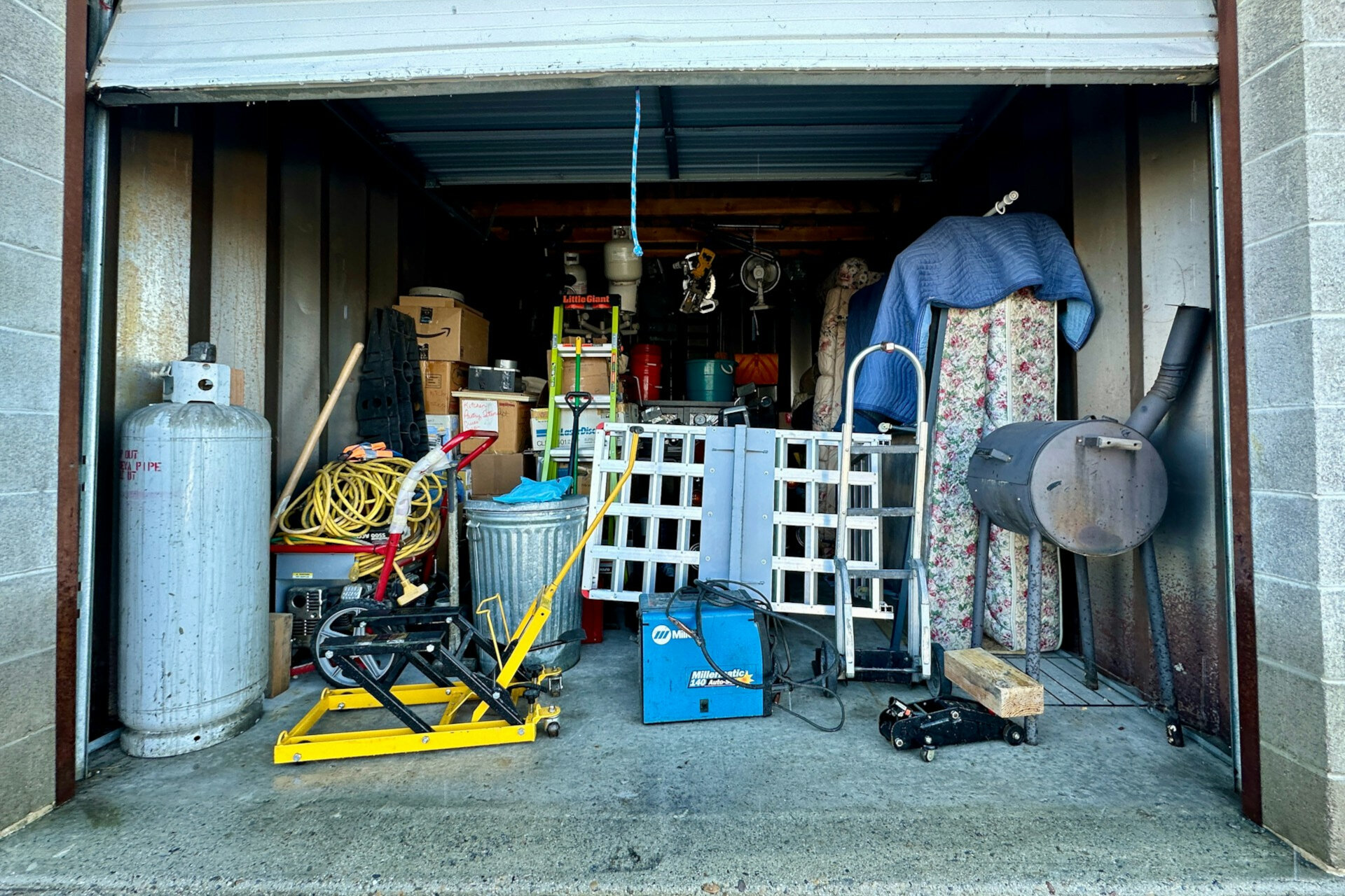 Innenansicht einer Garage, gefüllt mit diversen Gegenständen wie Werkzeugen, Kisten und einem Fahrrad. | © Adam Winger / Unsplash